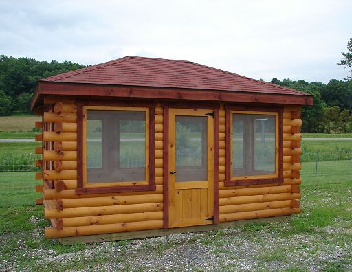 A small log cabin with a screened in door and windows