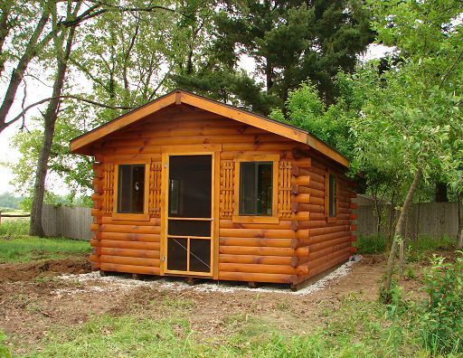 A small log cabin with a screened in door and windows