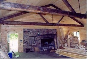 A room with a brick fireplace and wooden beams