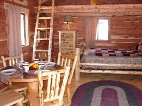 A log cabin with a table and chairs and a bed