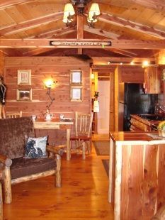 A living room in a log cabin with a table and chairs