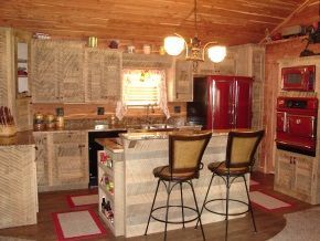 A kitchen with two bar stools and a red refrigerator