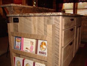 A kitchen island with a shelf of books on it.