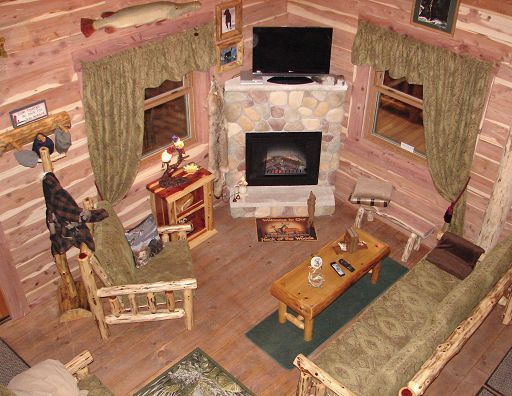 A living room in a log cabin with a fireplace and a flat screen tv