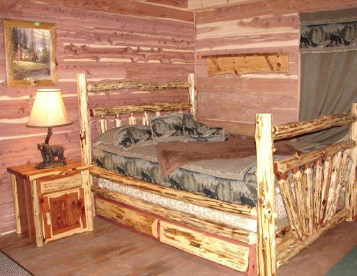 A bedroom with a bed and nightstand made of logs