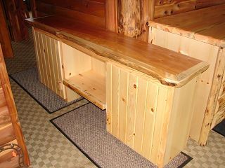 A wooden desk with a shelf underneath it in a room.