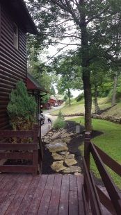 A wooden deck with a view of a house and trees.