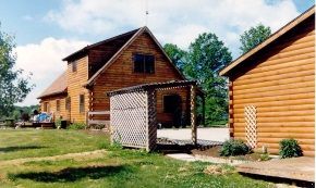 A log cabin with a shed in front of it