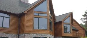 A large wooden house with a lot of windows and a gray roof.