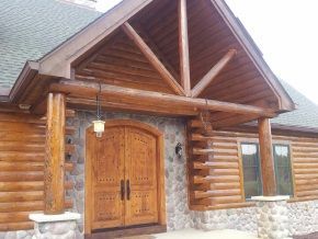 A log cabin with a porch and a wooden door