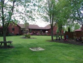 A large lawn with a fire pit in the middle of it