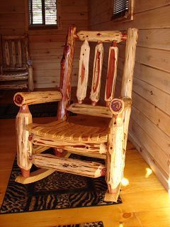 A wooden rocking chair is sitting on a rug in a room.