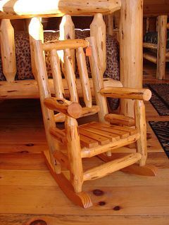 A wooden rocking chair is sitting on a wooden floor in a room.