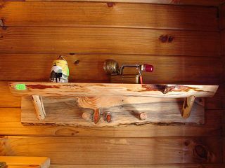 A wooden shelf with a salt and pepper shaker on it is hanging on a wooden wall.