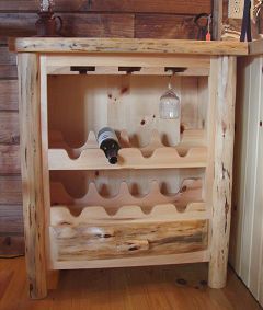 A wooden wine rack with a bottle of wine and glasses on it.