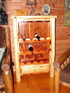 A wooden wine rack with bottles of wine on it in a living room.
