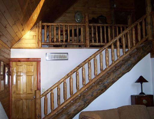 A wooden staircase leading up to the second floor of a cabin