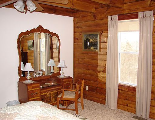 A bedroom in a log cabin with a large mirror