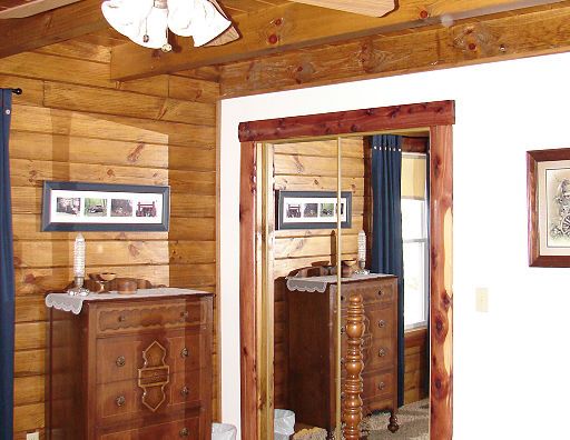 A bedroom with a dresser and a large mirror
