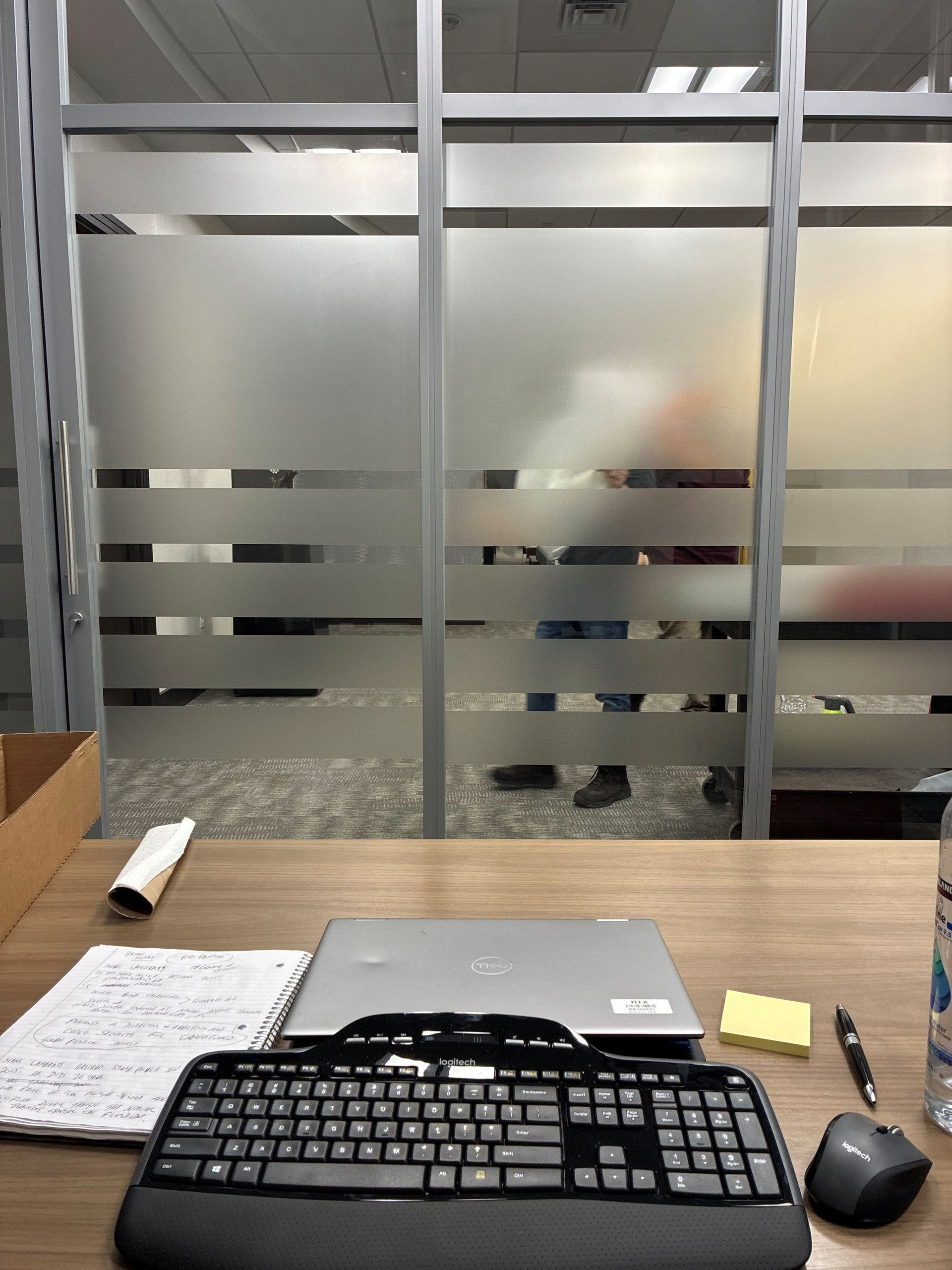 Person holding a large reflective sheet near a window, adjusting its edge.
