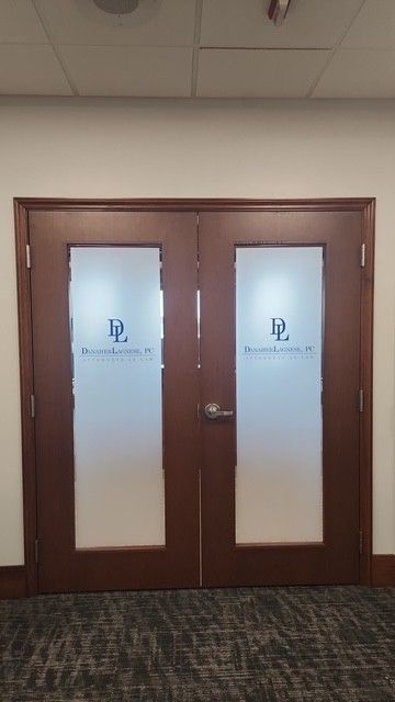 Brown double doors with frosted glass panes in a hallway
