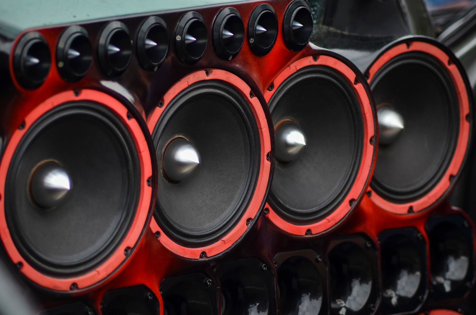 Row of large red and black speaker cones in a sound system array