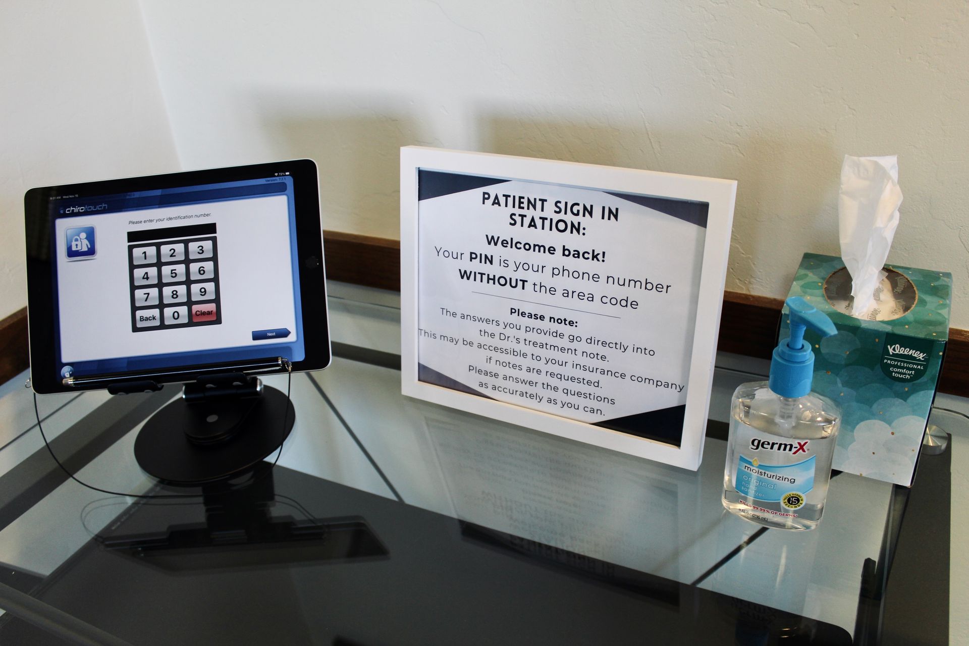 Patient sign-in station with tablet and supplies.