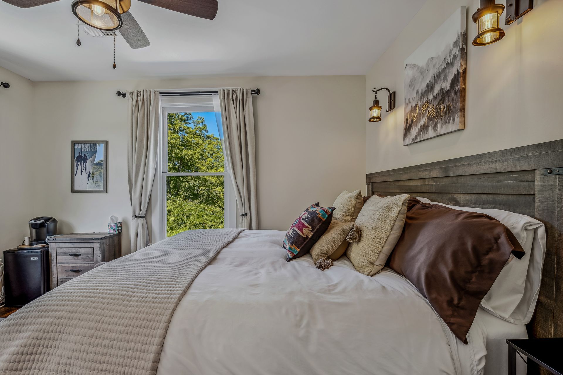 A bedroom with a king size bed and a ceiling fan.