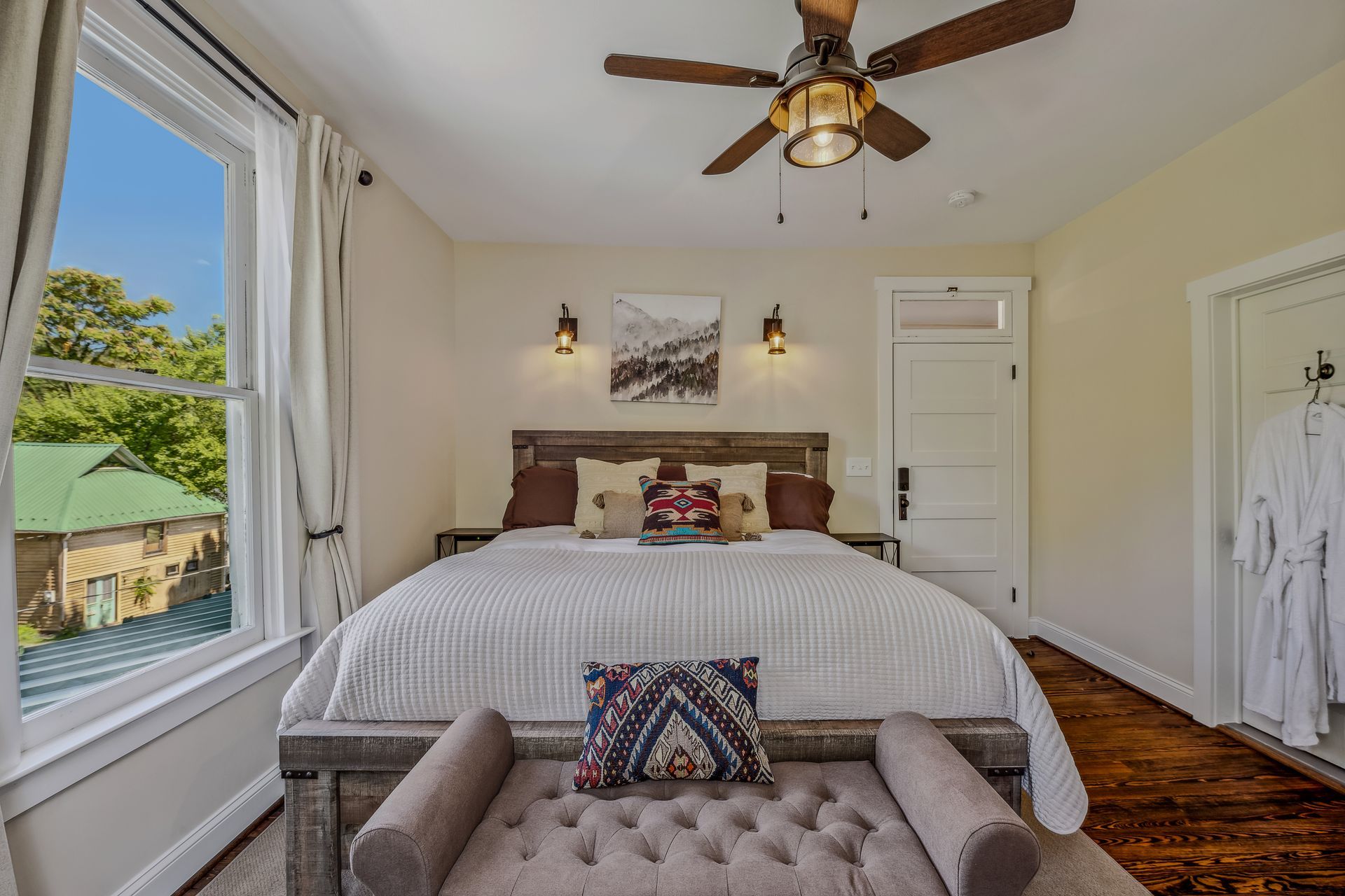 A bedroom with a king size bed and a ceiling fan.
