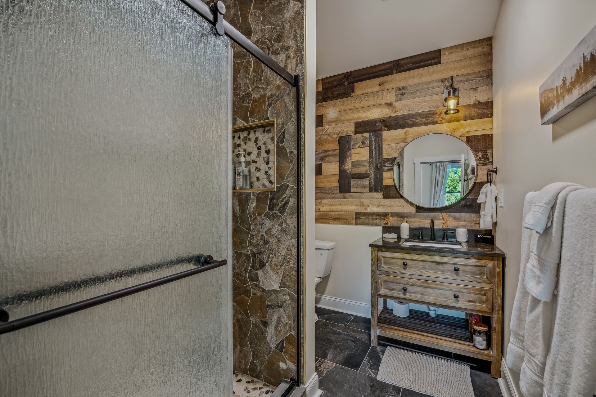 A bathroom with a walk in shower , sink , and mirror.