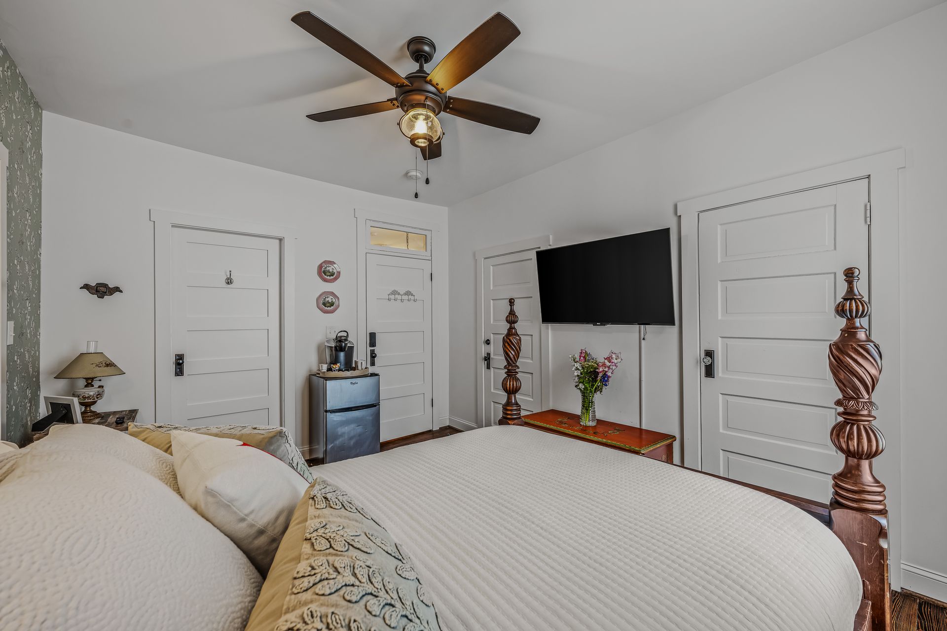 A bedroom with a bed , pillows , and a door.