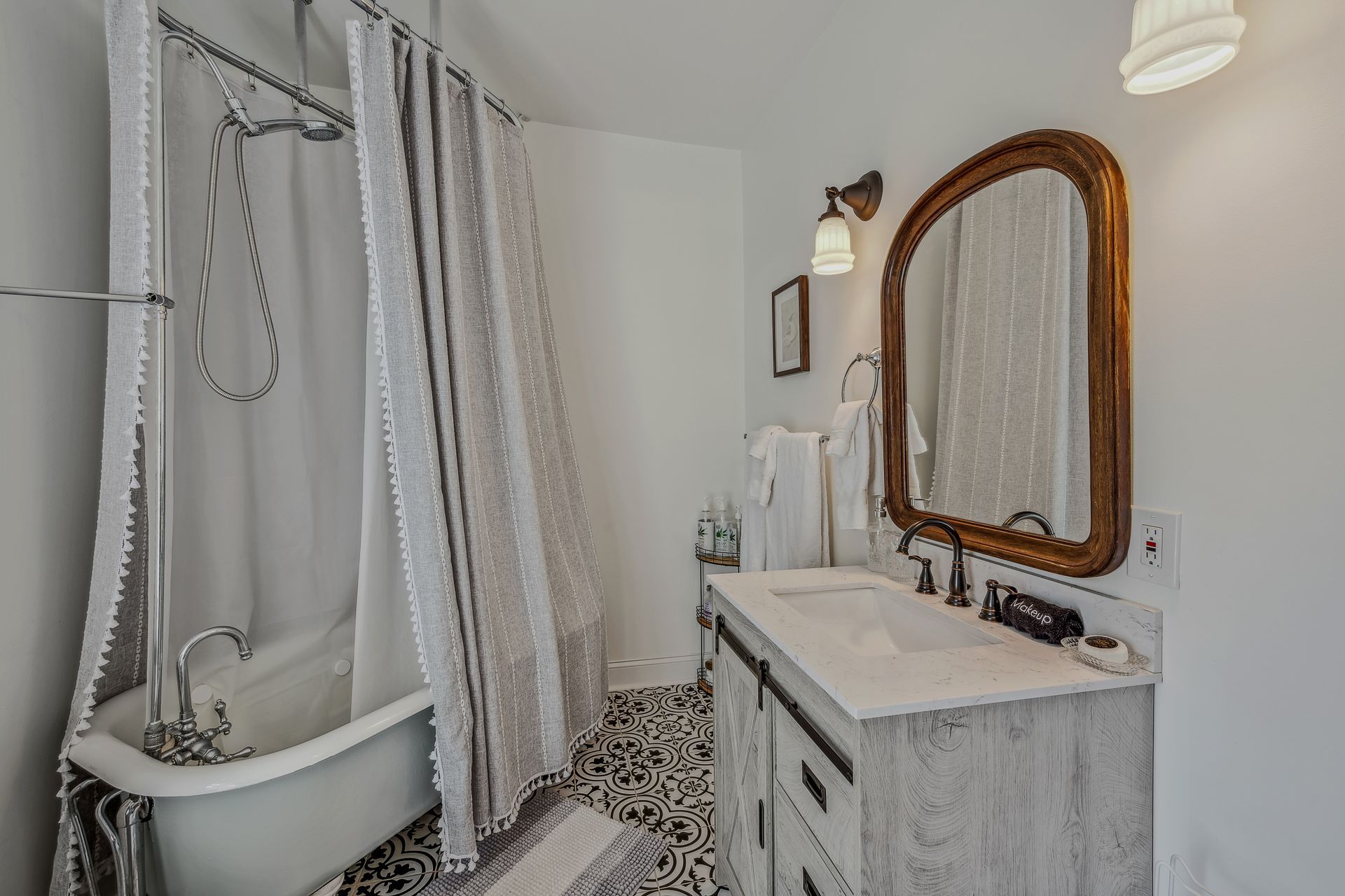 A bathroom with a tub , sink , mirror and shower curtain.