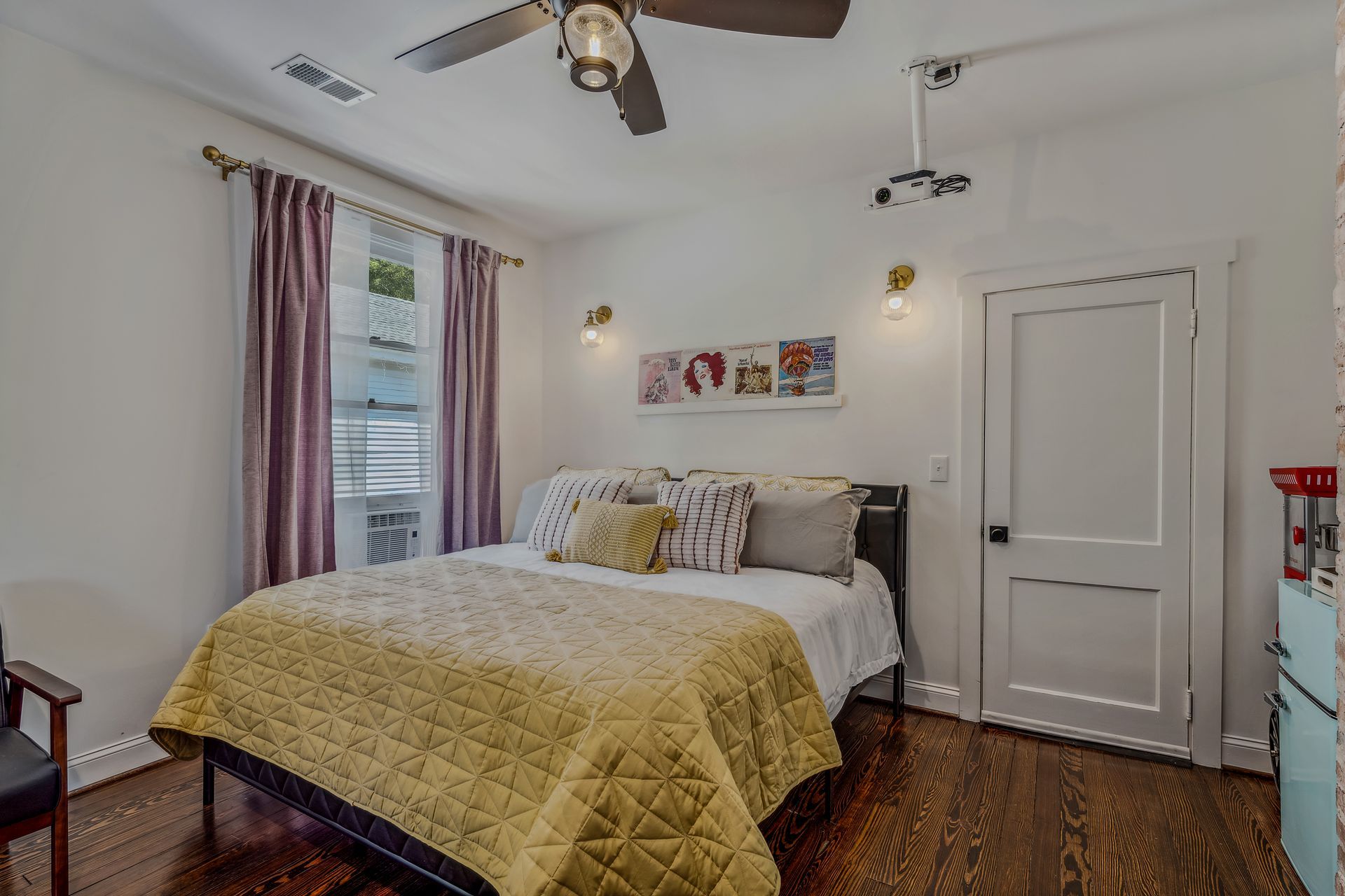 A bedroom with a bed and a ceiling fan.