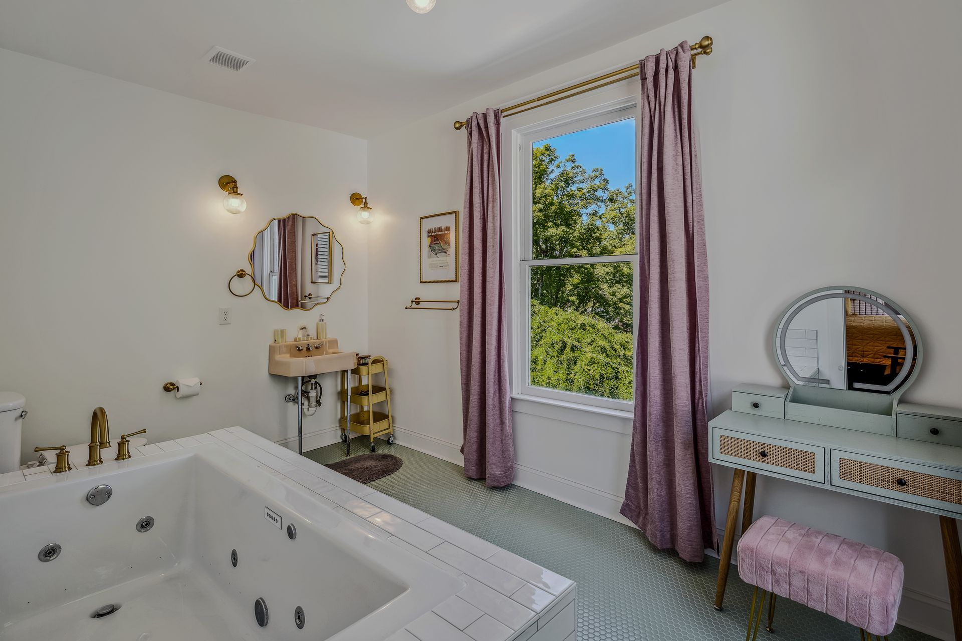 A bathroom with a jacuzzi tub , sink , mirror and vanity.