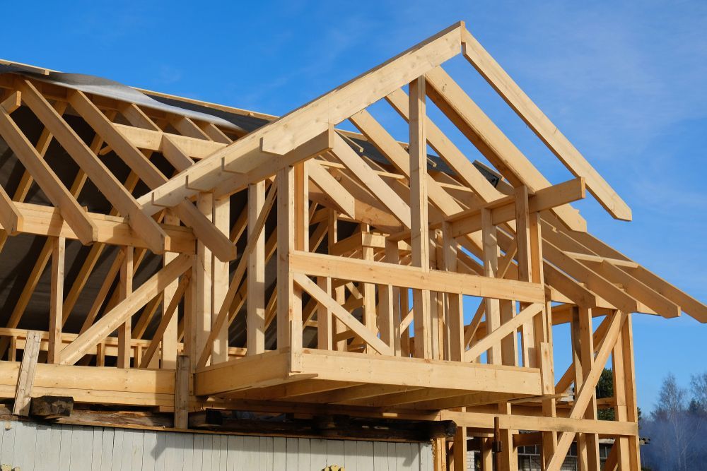 Wooden House Frame Under Construction Against a Blue Sky — Brayden Stewart Building In Forster, NSW