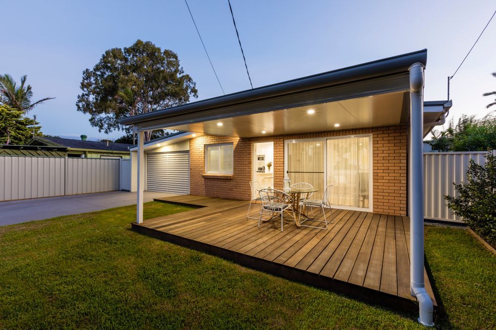 Backyard Patio With Wooden Deck, Brick House, and Dining — Brayden Stewart Building In Forster, NSW