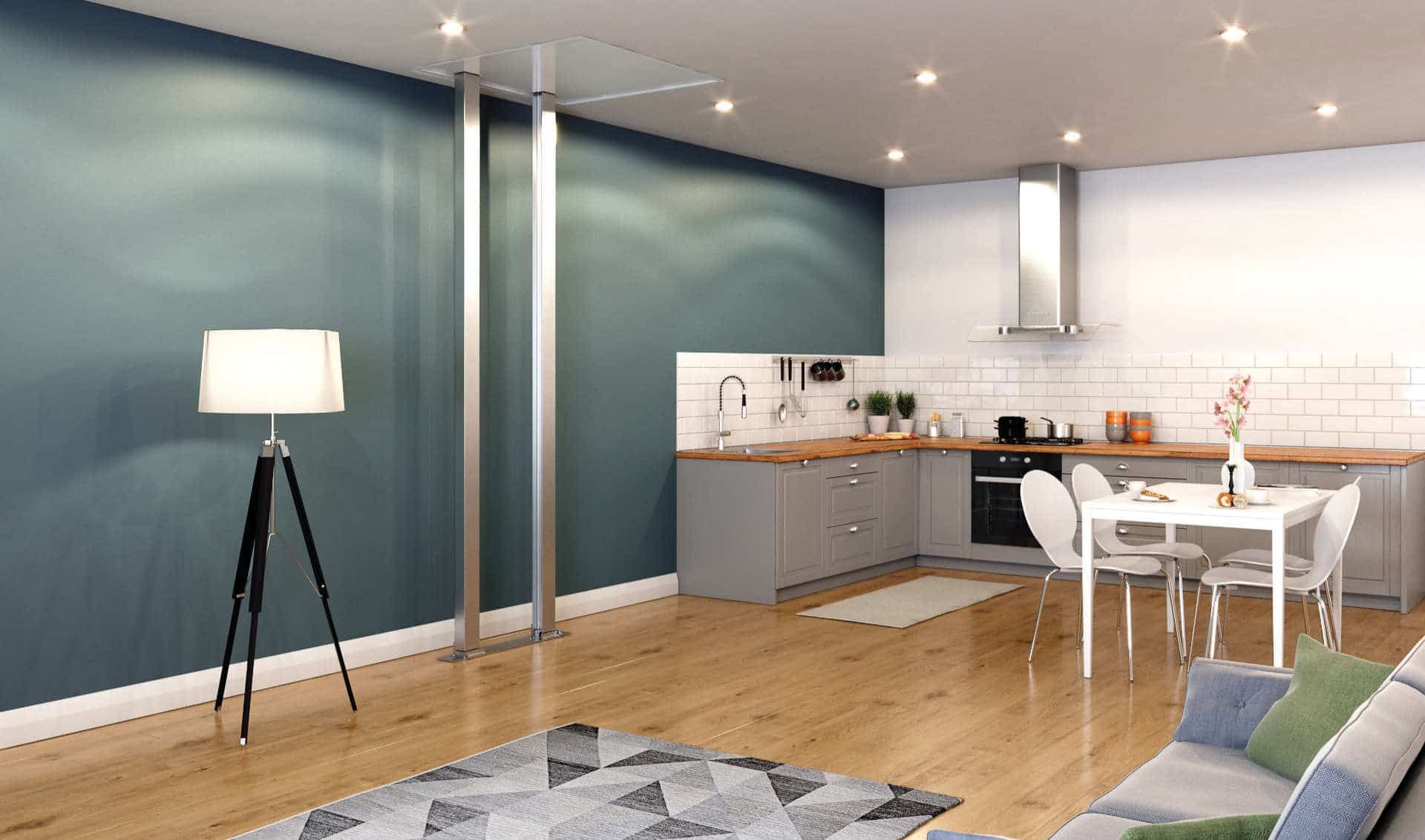 A modern open-plan living room with a blue accent wall, tripod floor lamp, gray kitchen, and small dining set.