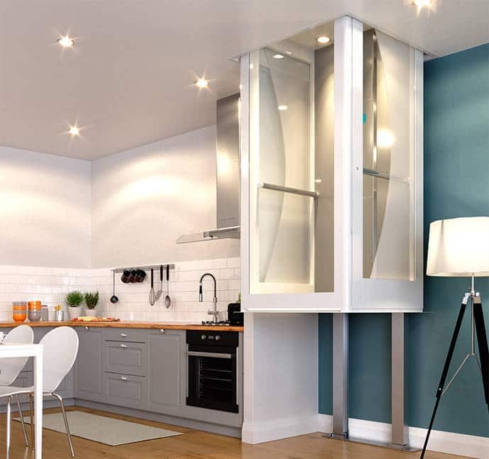A residential platform lift installed next to a modern kitchen counter with grey cabinets and a blue wall.
