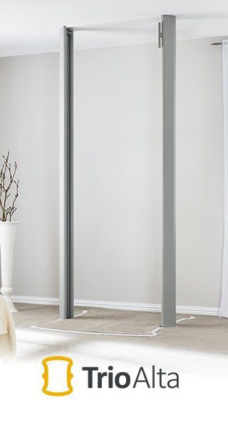 A grey, minimalist pull-up bar frame standing in a room, with the brand name 