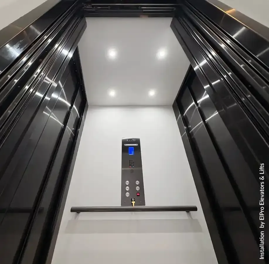 Elevator panel with up and down buttons, speaker grille, and red emergency stop button with wireless signal icon