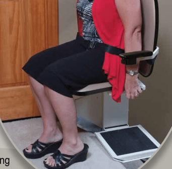 A Legacy II stairlift with a beige seat and armrests installed on a track, featuring a wireless remote control.