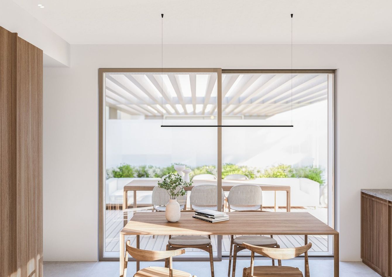 Sala da pranzo con tavolo in legno, sedie e una porta scorrevole in vetro che si affaccia su una terrazza esterna.