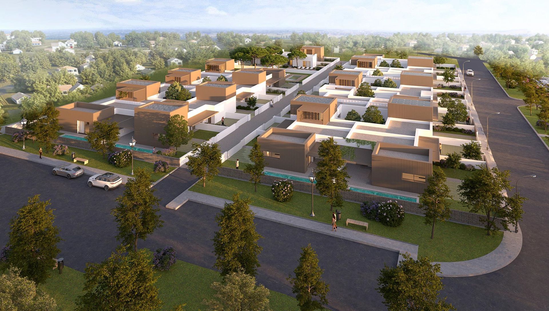 Veduta aerea di un moderno quartiere residenziale con case color beige, strade alberate e prati verdi.