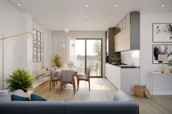 Moderno spazio abitativo open space: cucina, sala da pranzo e soggiorno con pavimenti in legno chiaro e colori neutri.