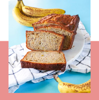 A loaf of banana bread is sitting on a plate next to bananas.
