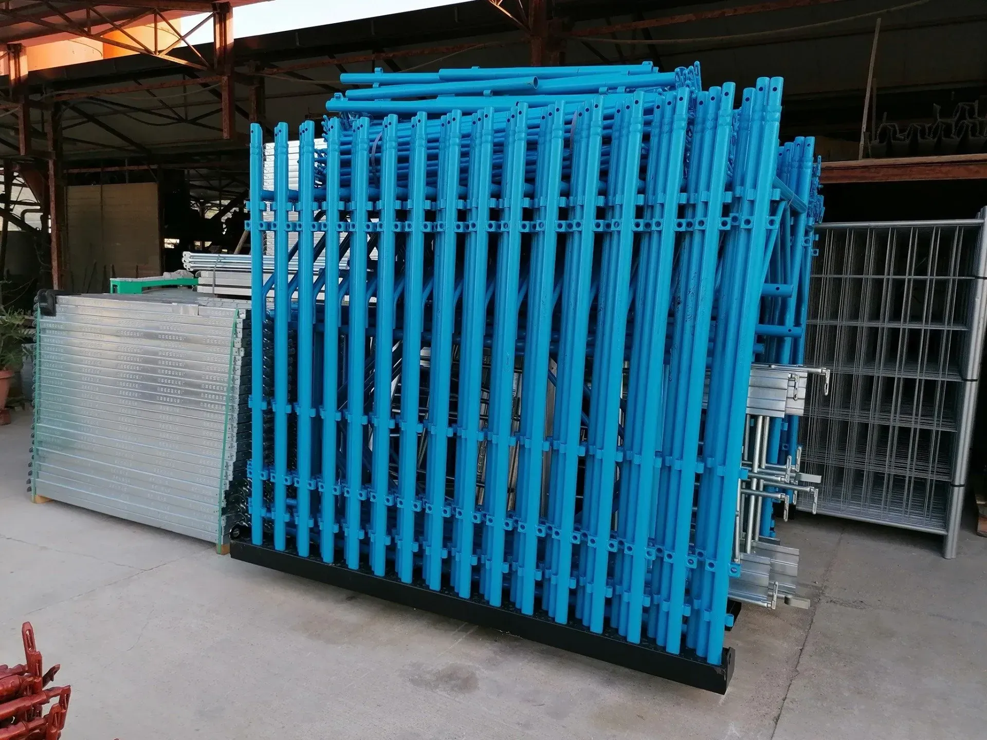 Macchinario industriale verde su un pallet di legno in un corridoio di un'officina, con un piccolo telo arancione sopra.