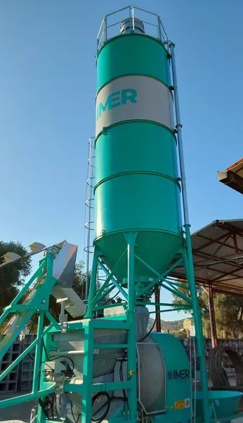 Coperchio o copertura per serbatoio in plastica ondulata verde con base piatta, all'aperto vicino a oggetti rossi impilati
