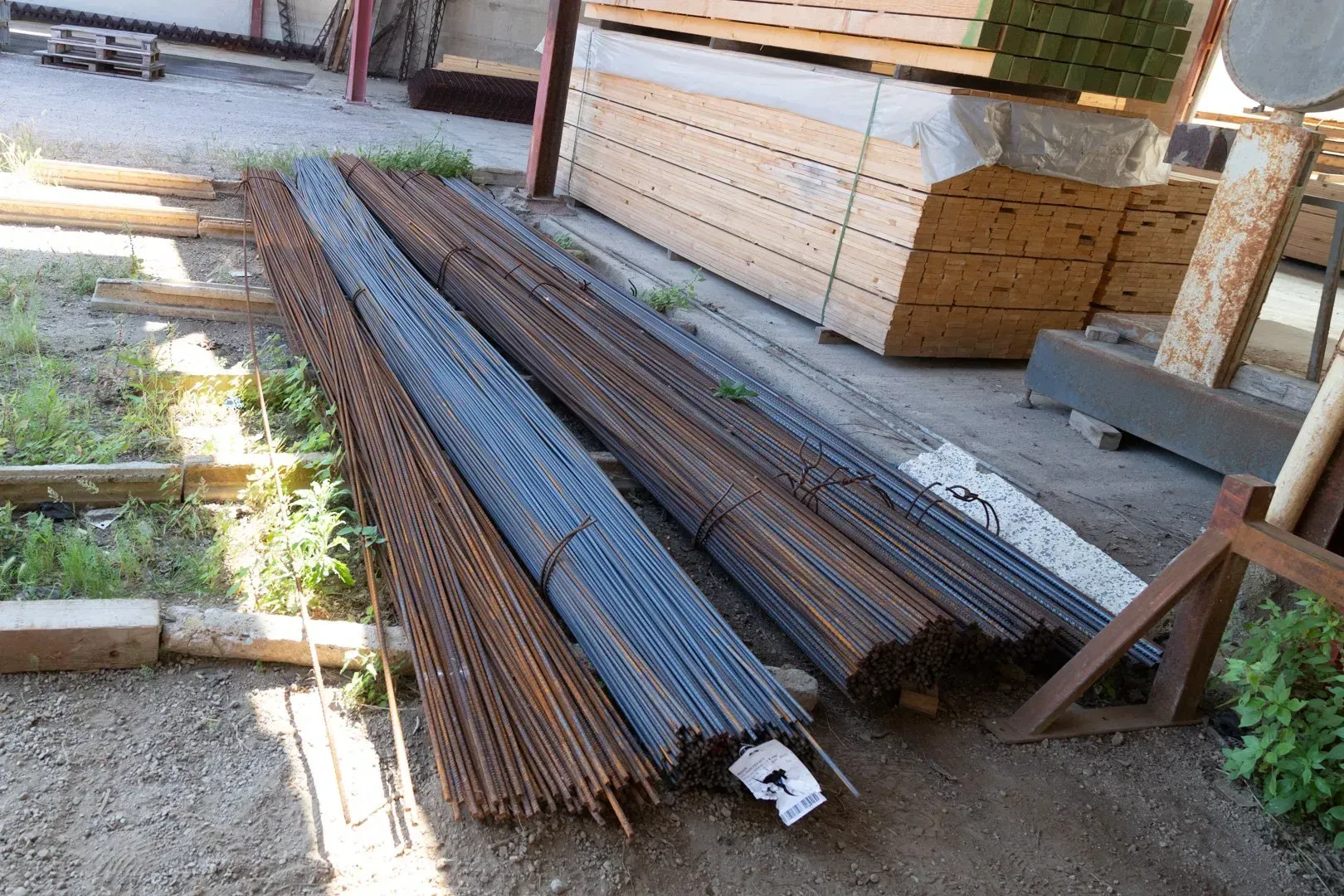 Pile di lamiere di rete metallica saldata color ruggine disposte in un magazzino o in un cantiere.
