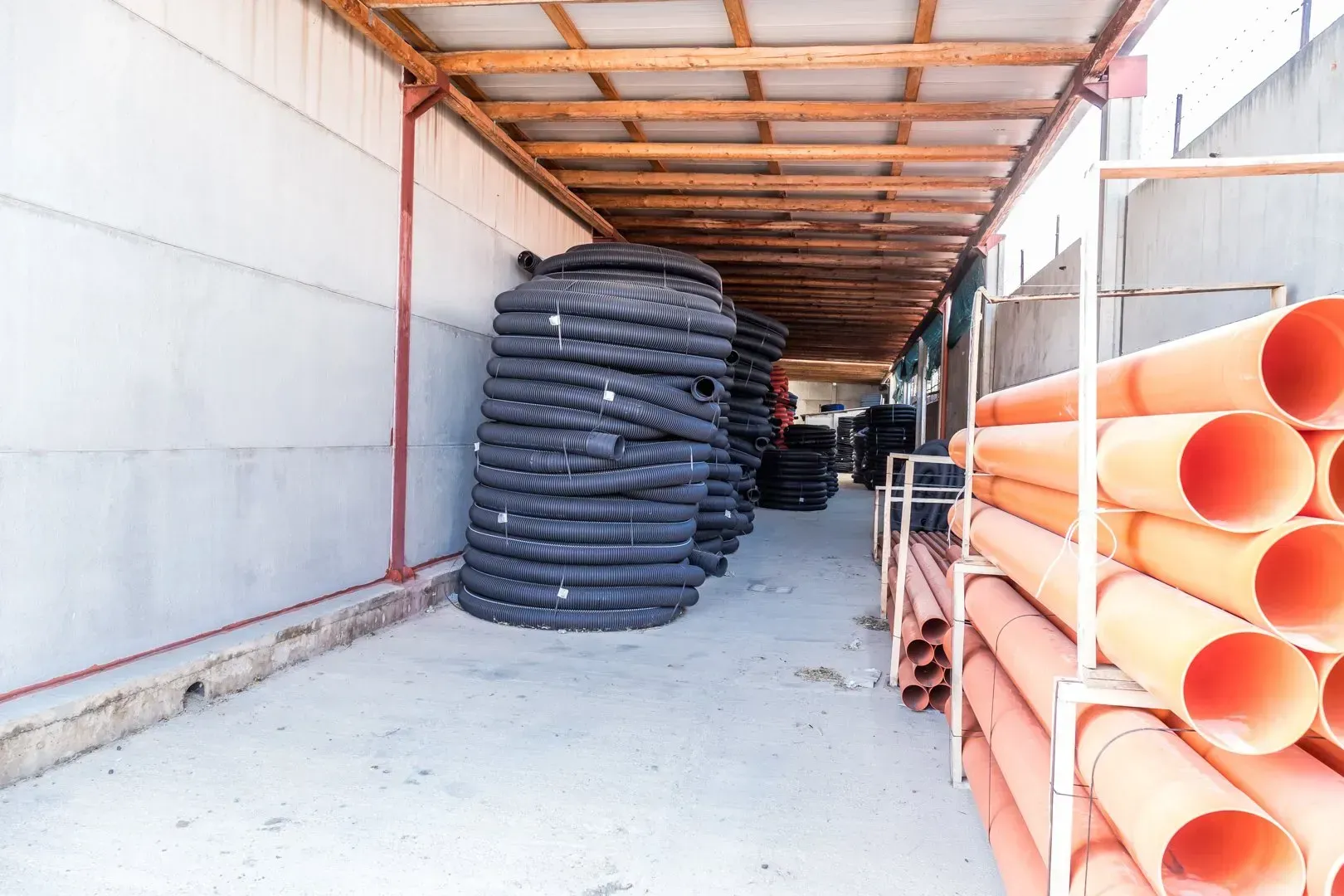 Pallet di materiali edili gialli e arancioni impilati in un corridoio di un magazzino