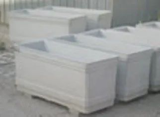 Pile di blocchi di polistirolo bianco rettangolari o blocchi da imballaggio su un pallet in un magazzino.